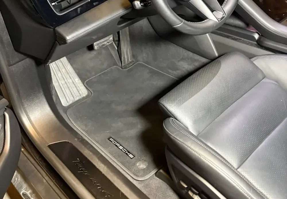 Interiøret i en Porsche Taycan etter innvendig vask hos Møgster Bilvask: rene matter og blank terskel.